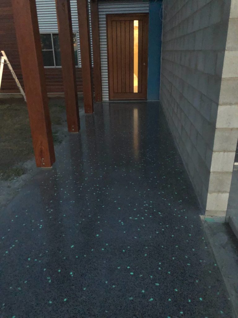 dark concrete leading to entrance of home